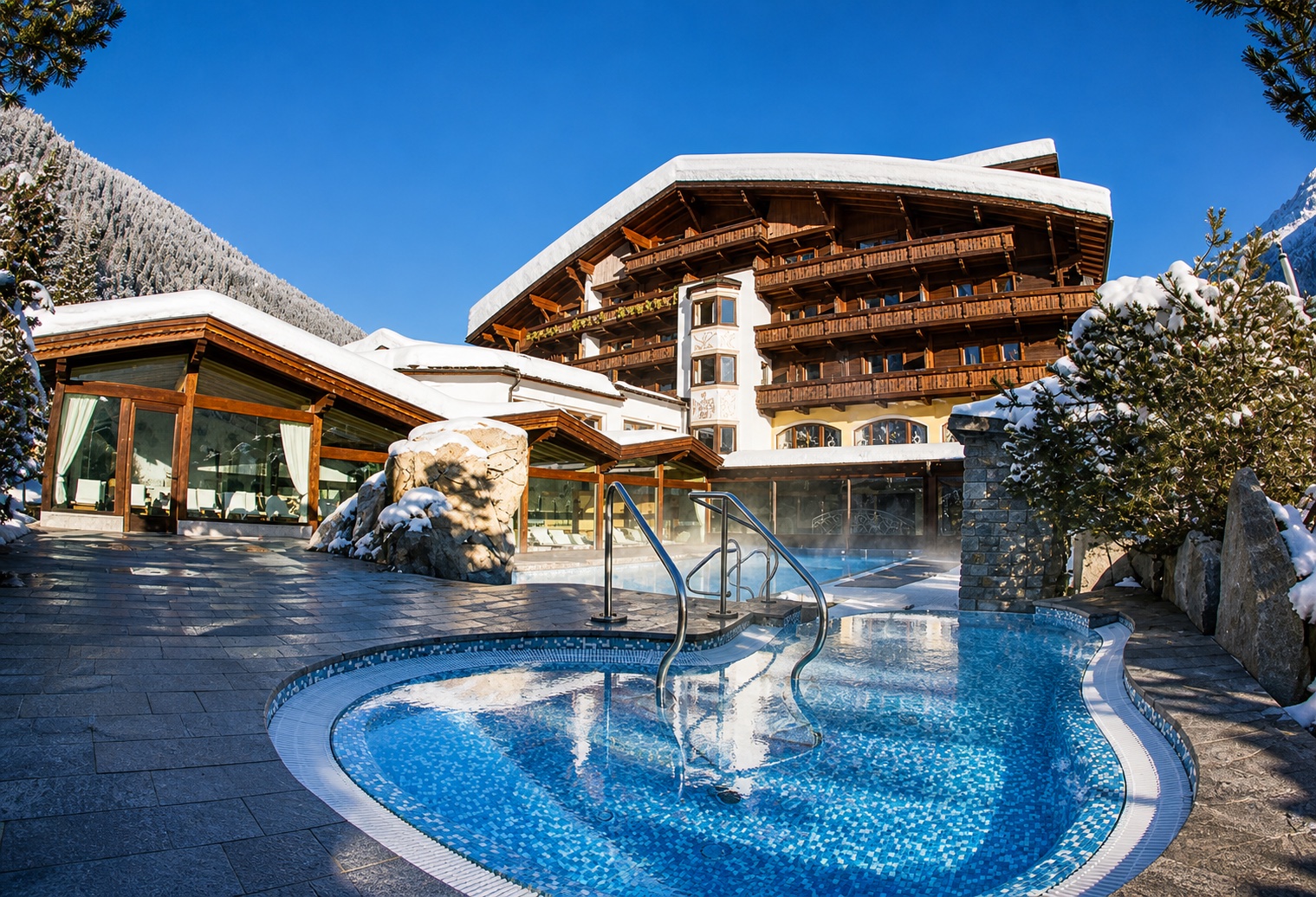 Alpine spa hotel with outdoor pool in winter